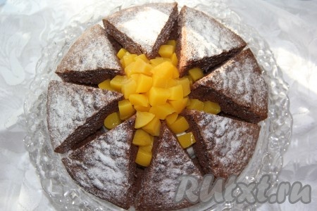 В середину выложить кусочки персиков. Посыпать торт "Килиманджаро" сахарной пудрой. А затем красивый, вкусный тортик можно подавать к столу. Приготовьте торт с суфле и консервированными персиками по этому рецепту и он, наверняка, понравится и вам, и вашим близким, и гостям!