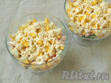 Выложить их слоем поверх крабовых палочек и смазать майонезом.