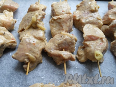 Противень застелить пергаментной бумагой или фольгой. Выложить мясо на противень. Если у вас нет деревянных шпажек, можно просто разложить кусочки мяса на противне (или в форме для запекания).