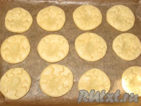 Затем на противень, застеленный пергаментом, с помощью кондитерского мешка с крупной фигурной насадкой высадить печенье в виде цветочка. У меня мешка нет, поэтому я тесто разделила на 21 шарик, выложила их на противень и слегка прижала (заготовки печенья должны находиться на расстоянии друг от друга), сделала узор ножом и чуть вдавила серединку.