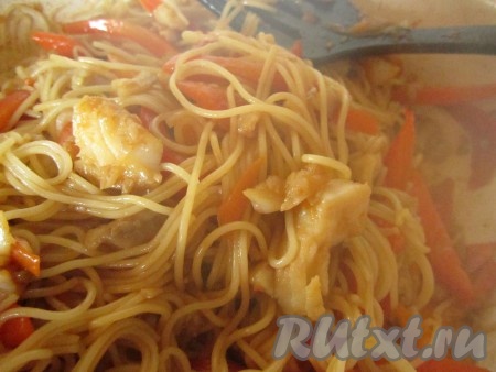 Добавьте к рыбе и овощам отваренную лапшу, хорошо и обжаривайте её с соусом ещё немного на большом огне. Лапшу нужно постоянно мешать.&nbsp;