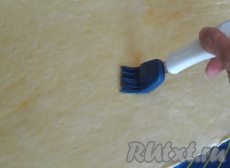 Снова раскатать тесто скалкой тонким слоем в прямоугольник, поверхность смазать оливковым маслом.