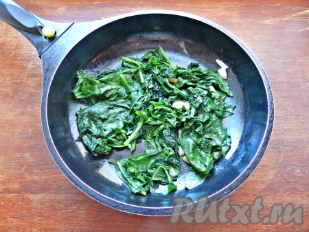 Выложить в сковороду шпинат и обжарить его с маслом и чесноком, помешивая. Как только шпинат уменьшится в объёме, снять сковороду с огня.