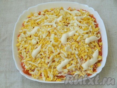 Яйца также натереть на тёрке. На смазанную майонезом морковь выложить яйца и нанести майонез.