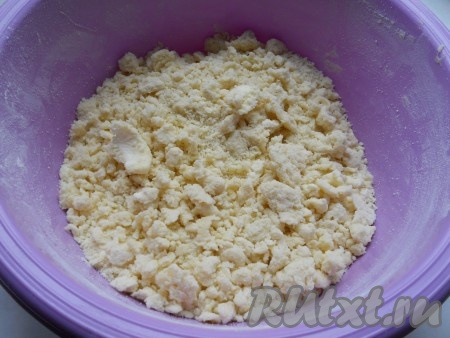 К получившейся мучной смеси добавить нарезанное на кусочки немного размягчённое сливочное масло, перетереть содержимое миски руками до получения крошки (крошка необязательно должна быть мелкой).