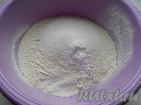 Сливочное масло достать заранее, чтобы оно слегка согрелось. Для замешивания теста нужно в глубокую миску просеять муку, добавить сахар и разрыхлитель, перемешать.