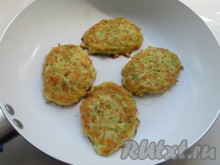 На сковороде прогреть растительное масло, выкладывать 1-1,5 столовых ложки кабачково-сырного теста в виде круглых оладушек. Жарить оладьи на среднем огне до румяности с двух сторон, затем выкладывать на тарелку. Перед жаркой очередной порции оладий тесто нужно перемешивать. Постепенно пожарить все оладушки. Я жарила оладьи по 2-3 минуты с каждой стороны.