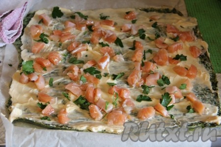 Готовый и горячий омлет завернуть с помощью полотенца в рулет. Оставить его в таком состояние на 5 минут. Развернуть омлет из шпината, смазать его поверхность творожным сыром, выложить кусочки филе сёмги и присыпать нарезанной петрушкой.