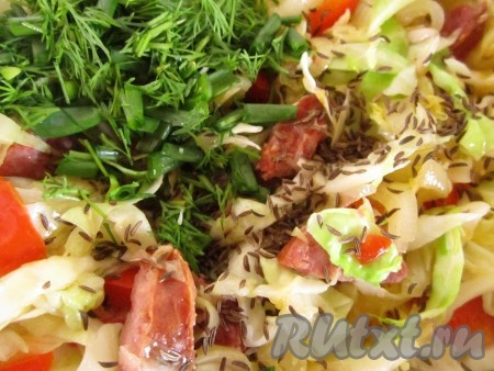 Зелень измельчите. Добавьте к тушёной капусте. Посыпьте блюдо тмином (количество - на Ваш вкус).