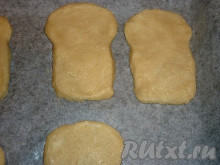 Через 30 минут достаём тесто и раскатываем его на присыпанной мукой поверхности в пласт толщиной 0,5-1 сантиметр. С помощью формочки или бумажного трафарета вырезаем печенье (я из бумаги вырезала трафарет в виде кулича и с помощью него вырезала печенье нужной формы). Кладём печенье на противень, застеленный бумагой для выпечки, и отправляем в разогретую до 180 градусов духовку на 15-20 минут.