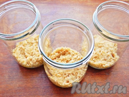 Крошку из печенья с маслом выложить поровну в банки и утрамбовать.