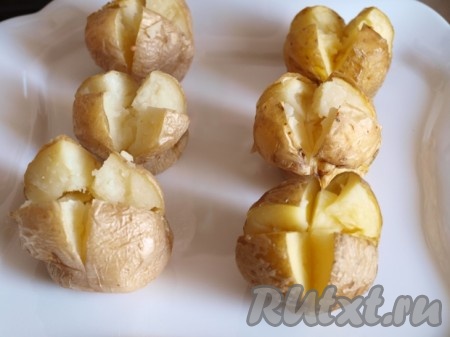 Выложить картофель на тарелку и на боковой более широкой части картофеля сделать крестообразные надрезы. Большим и указательным пальцем правой и левой руки придавить картофель с двух сторон как бы делая "талию". Разрез приоткроется как цветок.
