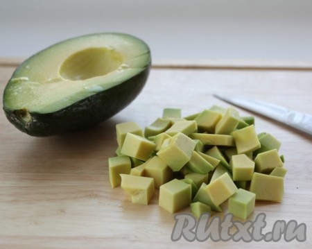 Из авокадо удалить косточку, очистить от шкурки и нарезать кубиками, сбрызнуть лимонным соком (лимонный сок не даст авокадо потемнеть).