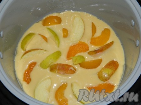 Вылить в мультиварку. На тесто выложить нарезанные персики и яблоки. Немного вдавить.
