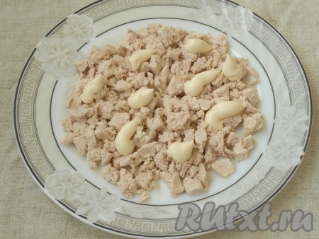 Куриное филе сварить в подсоленной воде до готовности (в течение 20-25 минут с момента закипания воды), полностью остудить. Яйца отварить в течение 10 минут с момента закипания воды, полностью остудить и очистить. Остывшее филе нарезать на маленькие кубики,&nbsp; выложить на плоскую тарелку. Смазать мясо майонезом.