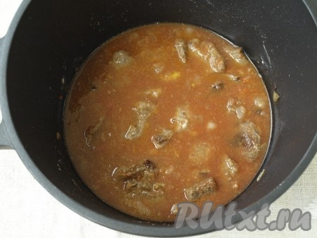 Соединить воду с томатным соком и влить к мясу. Добавить сахар и соль. Казан накрыть крышкой и тушить до мягкости мяса примерно 1 час.