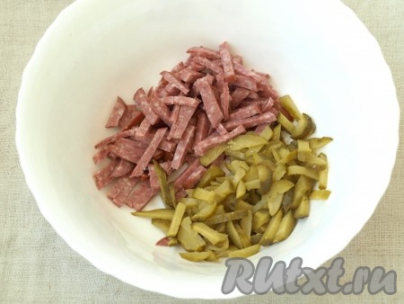 Нарезать соломкой копчёную колбасу и маринованный огурец.