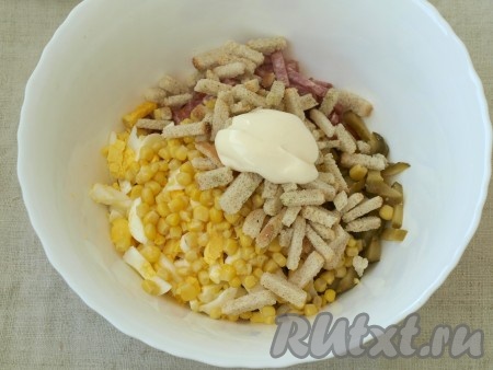 Добавить в миску половину сухариков, а половину оставить для подачи. В итоге часть сухариков станет мягкой, а часть будет хрустящей. Добавить майонез и перемешать.
