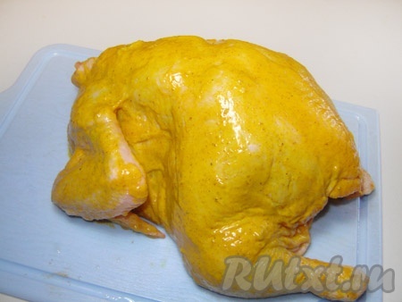 Натираем кожицу курицы смесью для придания золотистого оттенка.