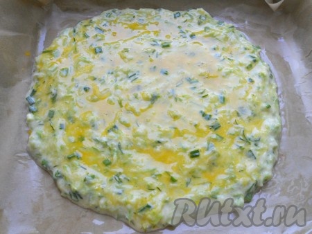 Противень застелить пергаментной бумагой, смазать её растительным маслом. Выложить кабачковую смесь в виде лепёшки толщиной около 1 сантиметра.&nbsp;