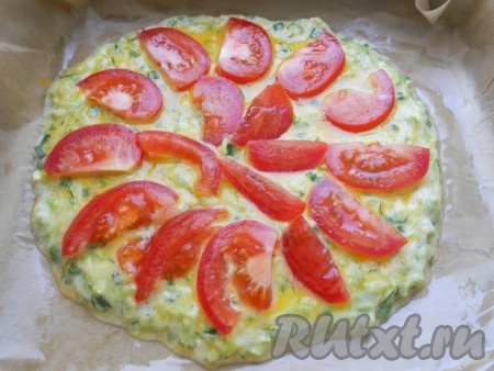 Помидоры вымыть, нарезать на тонкие полукружочки и разместить их на кабачковой лепёшке.