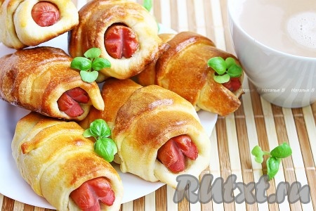 Готовые аппетитные сосиски в тесте выложить на блюдо, дать им немного остыть.