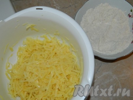 В одной миске соединить муку, специи, чёрный молотый перец, соль, перемешать мучную смесь. Картофель очистить, натереть на крупной тёрке, переложить в отдельную объёмную миску, влить яичные белки, немного посолить, тщательно перемешать картофельную массу.