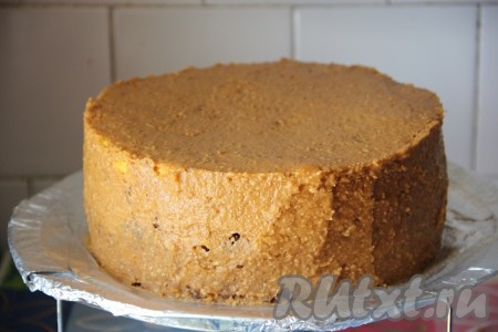 С помощью шпателя, тортовой лопатки или ножа наносим наш крем на торт. Этим кремом прекрасно можно выровнять вмятины или неровности. Когда весь крем использован и распределен по торту, приступим к выравниванию поверхности.
