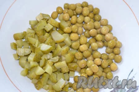 Яйца заранее сварить в течение 10 минут с момента закипания воды, остудить их и очистить. В миску сложить зелёный горошек, нарезанные на небольшие кубики огурцы.