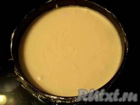 Вылить творожную массу в форму. Форму предварительно обернуть несколькими слоями фольги. Поставить форму с чизкейком в глубокий поддон, налить на 1/3 высоты формы воды.&nbsp; Выпекать при температуре&nbsp; 200 градусов 25 минут, затем температуру снизить до 170 градусов и печь еще 20 минут. Края готового чизкейка должны немного схватиться, а серединка подрагивать.
