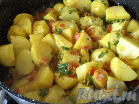 Добавить в сковороду к специям и помидорам готовый картофель и мелко нарезанную петрушку. Посолить и хорошо перемешать. Подержать на огне 5-7 минут.