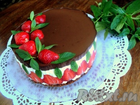 Снять с торта разъемное кольцо и бумагу для выпечки. Украсить торт клубникой и листиками свежей мяты.