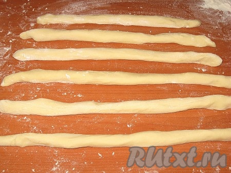 Затем тесто разделить на несколько частей, из каждой скатать тонкие жгутики, можно между ладоней, можно на чистом столе (на присыпанном скатываться не будут).