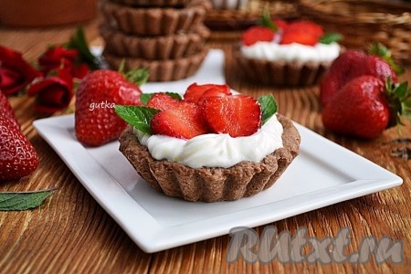 Для приготовления крема взбить маскарпоне вместе со сливками, добавить сахарную пудру и перемешать. Кремом наполнить остывшие песочные шоколадные корзинки. Клубнику вымыть, нарезать и выложить на крем.
