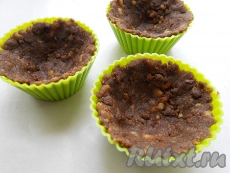 Разложить массу из печенья по силиконовым формочкам для кексов, хорошо прижимая массу к краям, чтобы получились корзиночки. Поместить формочки в холодильник на 30 минут.