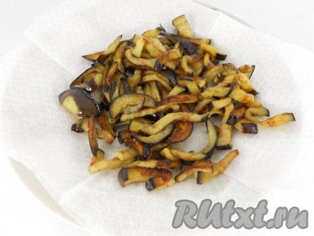 Затем обжарить баклажаны на растительном масле на довольно сильном огне до румяной корочки, все время помешивая. Выложить на бумажную салфетку для удаления лишнего масла. Дать остыть.
