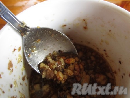 Добавьте измельчённые орехи в заправку и хорошо перемешайте.