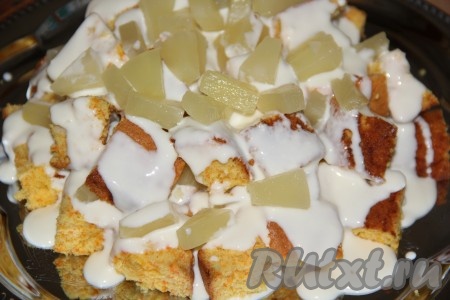 Кольца ананаса обсушить, выложив на бумажное полотенце, затем нарезать на кусочки. Для того чтобы собрать морковный торт, нужно обмакивать кусочки коржа в сметанный крем и выкладывать, чередуя с кусочками ананаса, на плоскую тарелку в виде горки.