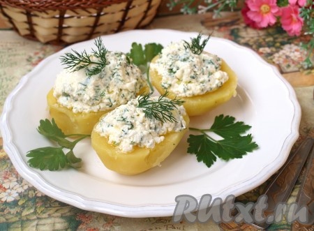 Горячий картофель разрезать пополам и выложить на блюдо. Сверху горкой выложить творожную массу. За счёт содержания в ней сливочного масла она будет немного подтаивать и пропитывать картофель. Получится безумно вкусно! 
