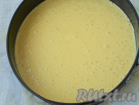 На дно разъёмной формы проложить пергамент и застегнуть кольцо. Вылить тесто. Форму крутануть по часовой стрелке пару раз, чтобы тесто прилипло к стенкам и в центре не образовался купол.