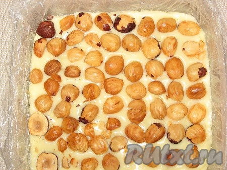 Разровнять, чтобы вишни не было видно, сверху выложить орешки, также слегка вдавливая их в массу.
