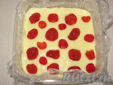 Выложить массу в квадратную емкость (у меня 12х12 см), застеленную пищевой пленкой. Сверху разложить вишню.
