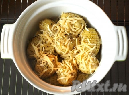 Разогреть духовку до 180 градусов и запекать картофель с надрезами до готовности. Время запекания зависит от сорта и размера картошки, мне понадобилось 50 минут. Затем картофель посыпать натёртым сыром и оставить в духовке ещё на 7-10 минут, чтобы сыр успел расплавиться.