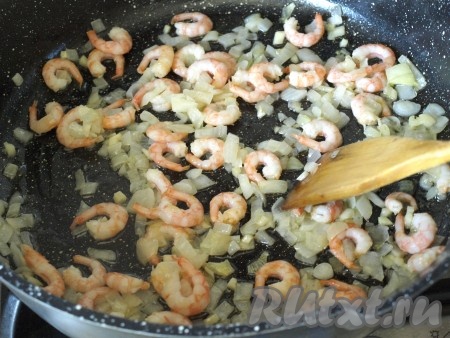 В сковороду добавить креветки и жарить их 1 минуту на сильном огне.