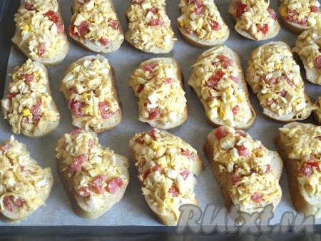 Ломтики батона смазать начинкой и выложить на противень, застеленный пергаментом.