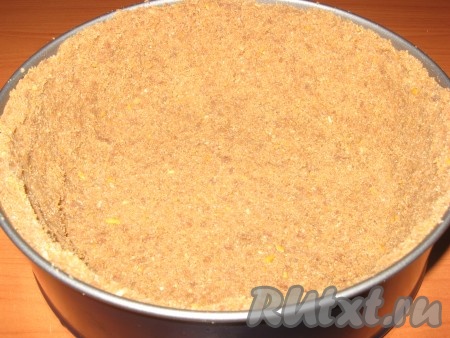 Крошку выложить в форму для выпечки (у меня разъёмная диаметром 22 см), равномерно и плотно прижать ко дну и бортикам формы, убрать в холодильник на 30 минут.