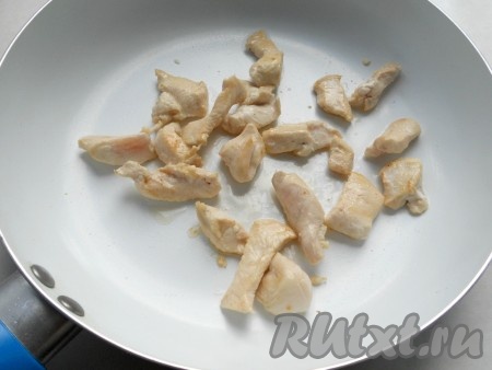 Куриное филе промыть и обсушить, нарезать на небольшие кусочки и обжарить на хорошо разогретой сковороде с добавлением растительного масла в течение 4-5 минут на среднем огне, периодически помешивая.