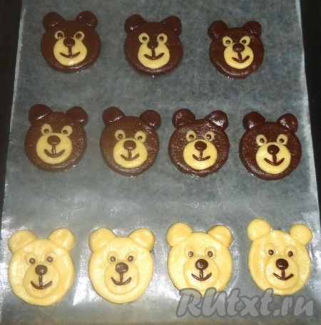 Противень застелить пекарской бумагой, смазать растительным маслом, выложить круги из теста, из подготовленных тёмных кусочков теста сформировать "уши", кусочки светлого теста раскатать в круг и выложить на тёмное тесто. Также оформить и светлых "мишек". Из светлого и тёмного теста сформировать "глаза", из тёмного теста сформировать "нос" и "рот". Выпекать печенье при температуре 170-180 градусов 15-20 минут в зависимости от духовки, нужно следить за тем, чтобы светлое печенье сильно не зарумянилось.
