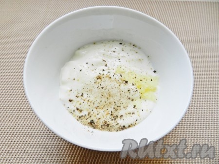 Приготовить заправку для салата. Для этого в йогурт выдавить чеснок, добавить по вкусу соль и перец, все перемешать.