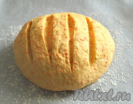 Затем из теста сформировать круглую буханку и выложить на противень, застеленный пергаментом и присыпанный мукой. По верху морковного хлеба сделать надрезы.